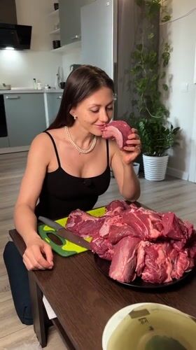 Woman prepares raw meat in Murino kitchen