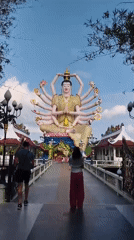 Morning visitors explore Wat Plai Laem Buddhist temple complex Thailand