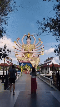 Morning visitors explore Wat Plai Laem Buddhist temple complex Thailand
