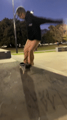 Skateboarder performs tricks at Buenos Aires park at dusk