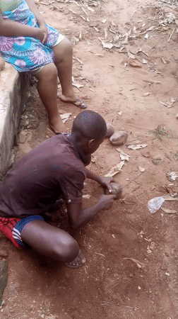 Man processes coconut outdoors in Ukwu-Abwa, Nigeria
