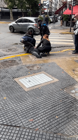 Bystanders assist man on Buenos Aires sidewalk