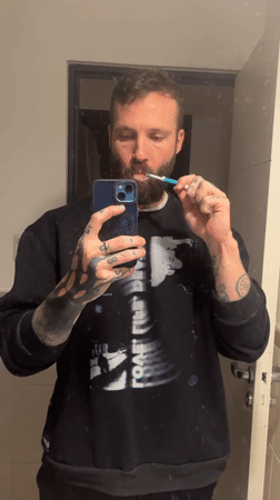 Man brushes teeth in Cordoba bathroom early morning