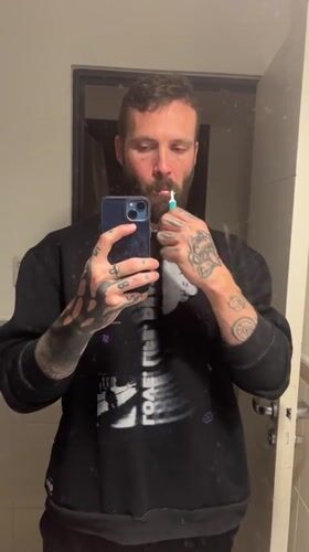 Man brushes teeth in Cordoba bathroom early morning