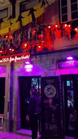 Nighttime street activity captured outside Lisbon bar with azulejo tiles