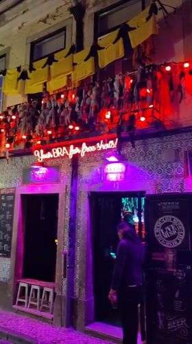 Nighttime street activity captured outside Lisbon bar with azulejo tiles