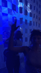 Women dance at blue-lit London venue with DJ