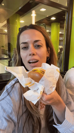 Woman enjoys burger at Belgrade restaurant with green walls