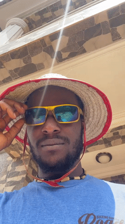 Man in straw hat documented at Abuja home studio