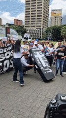 Coordinated protest with signs, banners documented in Caracas plaza