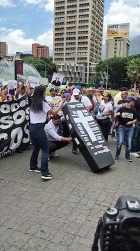 Coordinated protest with signs, banners documented in Caracas plaza