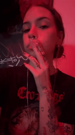 Tattooed woman smoking cigarette captured in Buenos Aires nighttime scene