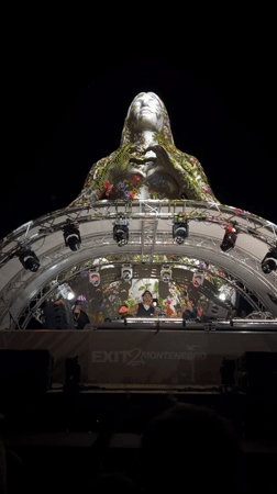 DJ set plays beneath a decorated statue in Montenegro