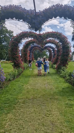 Heart-shaped floral arches line a garden path in Lithuania
