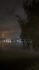 Night out near a lit waterfront with landmark architecture nearby