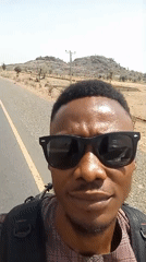 Man with backpack walks along road in Bauchi
