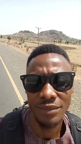 Man with backpack walks along road in Bauchi