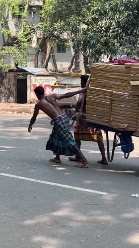 Two men transport packages by hand cart in Dhaka
