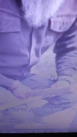 The video appears to be a nature documentary segment, possibly related to survival skills or an expedition. The primary subject is a person, dressed in outdoor clothing, seemingly engaged in an activity in a natural environment. The scene is somewhat blurry and grainy, suggesting it might be a recording from an older camera or a low-resolution capture.

The person is shown in a reclined or prone position, with their face visible and appearing somewhat relaxed or focused. The background consists of what looks like trees and dry ground, suggesting an outdoor setting, possibly a forest or a wooded area during a cooler season due to the presence of what could be dead leaves or sparse foliage. The lighting suggests it could be daytime, though the exact time of day is difficult to ascertain. There are no clear indicators of weather conditions, but the overall impression is of a natural, uncultivated environment.

There is some visible text in the video, appearing vertically on the right side of the frame. While difficult to read clearly due to the image quality and orientation, some letters are discernible, hinting at potential captions or credits. The text appears to be in a Latin-based alphabet.

The activity depicted seems to be related to survival or outdoor living, as the initial text overlay mentions "Survival in Turkey" and "teaching to survive in the wild with the help of improvised means." This suggests the person might be demonstrating or practicing survival techniques. The emotional tone, based on the limited visibility of the person's face, appears calm and concentrated. The location context provided, Pereshchepyne, Ukraine, adds a specific geographical detail to the setting, although the visuals themselves don't offer explicit clues to this location.