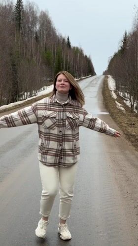 Woman dances, lies on empty road in Zasechnyi, Russia