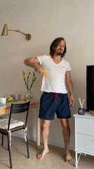 Man holds banana while smiling in residential room