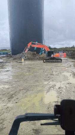 Inside a truck cab at a rainy Tallinn demolition site