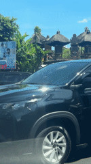 Police motorcycle stops behind SUV in Ubud, Indonesia