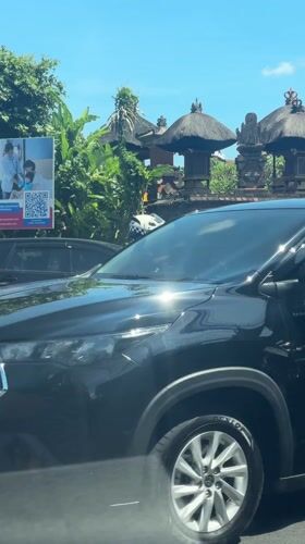 Police motorcycle stops behind SUV in Ubud, Indonesia