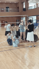 Dance group rehearses routine in gymnasium with instructor