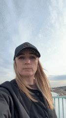 Woman in NY cap poses on St. Petersburg bridge