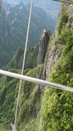 Cable car passenger films green mountain scenery in Yongding District