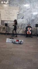 Musicians perform violin and cello in subway station