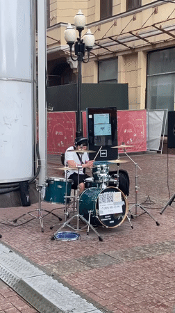 Street drummer performs on green kit in Moscow