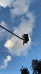 Red traffic light observed against blue sky in Haifa