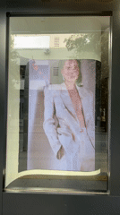 Storefront displays looping video of person in white suit