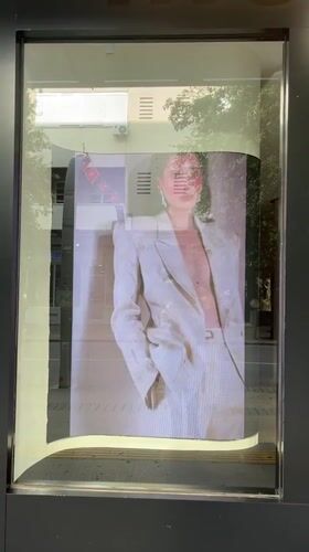 Storefront displays looping video of person in white suit