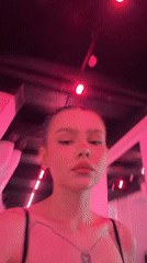 Woman observed in pink-lit Moscow corridor