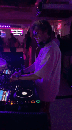 DJ working the decks in a dimly lit Ko Samui club