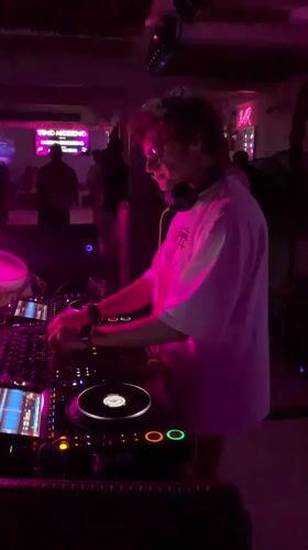 DJ working the decks in a dimly lit Ko Samui club