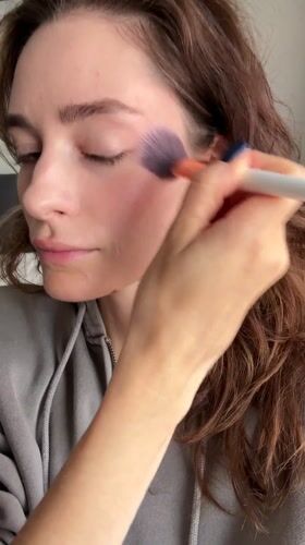 Woman applies makeup during morning routine in Kiel