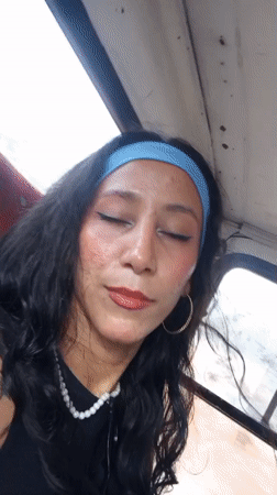 Woman in pearls and headband observed on bus