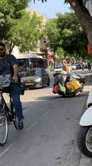Cyclist and woman with cart spotted on Tel Aviv street