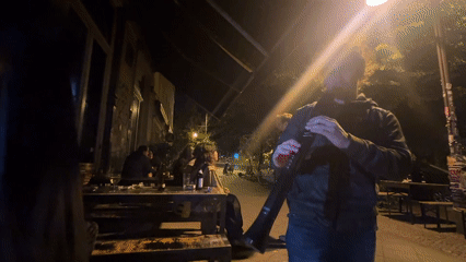 Musician plays electronic wind instrument in nighttime Berlin performance