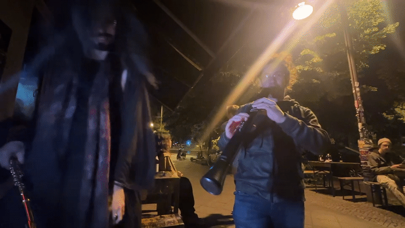 Musician plays electronic wind instrument in nighttime Berlin performance