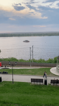 Sunset observed over Kama River in Perm with boat traffic