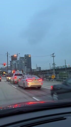 Vehicle travels New Westminster street under overcast afternoon sky