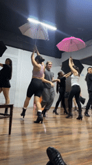 Dance rehearsal with umbrellas and fabric props in Mexican studio