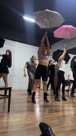 Dance rehearsal with umbrellas and fabric props in Mexican studio