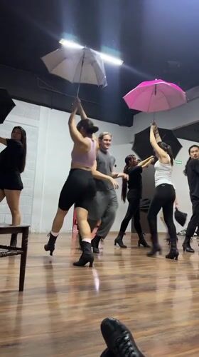 Dance rehearsal with umbrellas and fabric props in Mexican studio
