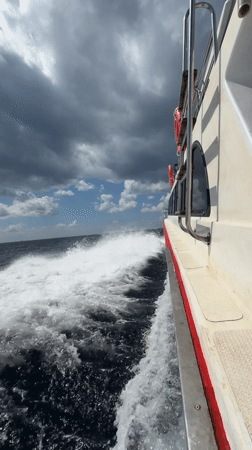 Motorboat arriving at a Nusa Penida beach under cloudy skies